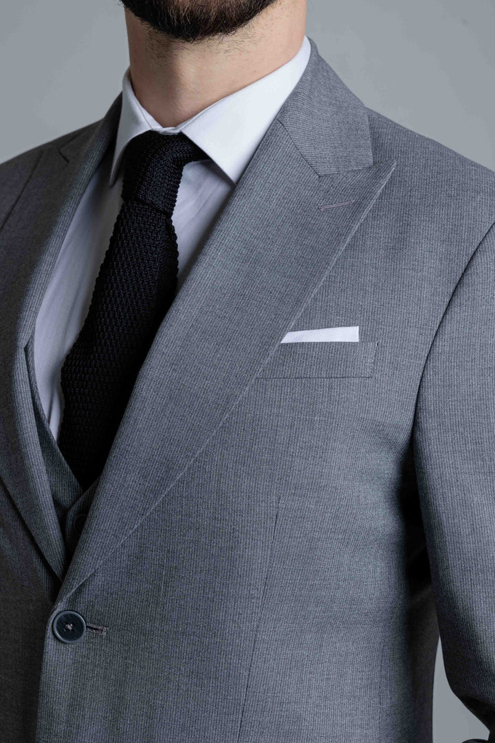 Trijų dalių pilkas kostiumas su plonų linijų tekstūra