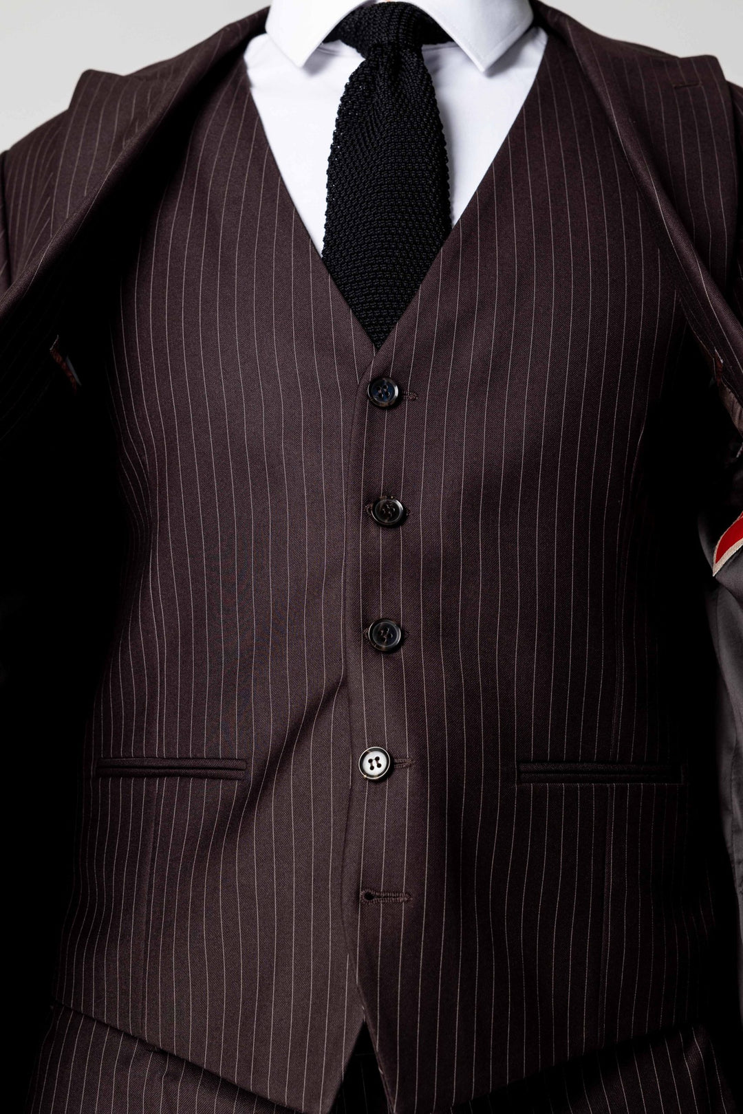 Trijų dalių tamsiai rudas kostiumas su linijomis