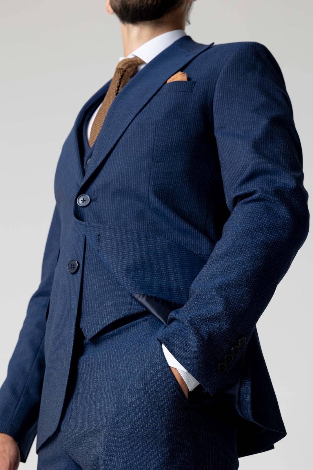 Trijų dalių mėlynas kostiumas su smulkiomis linijomis